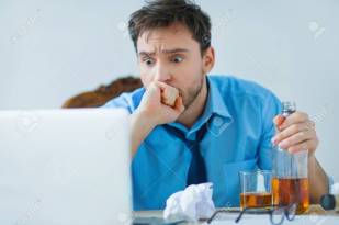 Drunk man drinking alcohol while working