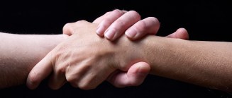 Male and female hands together on black background